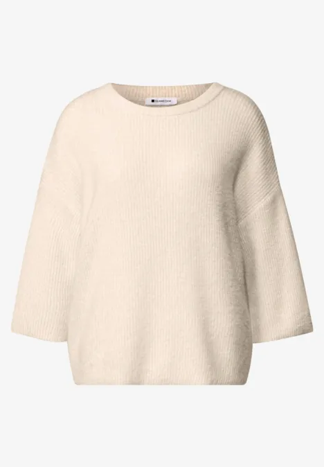 Pull en maille beige doux, coupe ample, encolure bateau et manches trois quarts.