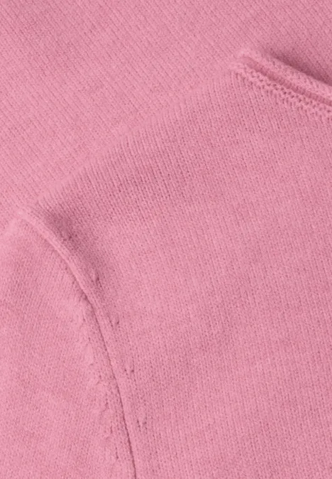 Nahaufnahme von rosafarbenem Sweatshirtstoff mit Nähnaht und Taschelement.