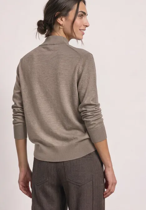Basic Pullover mit Turtle Neck sanded amber mel. Frau von hinten in beige Pullover und brauner Hose, dunkle Haare im Dutt, blickt zur Seite.
