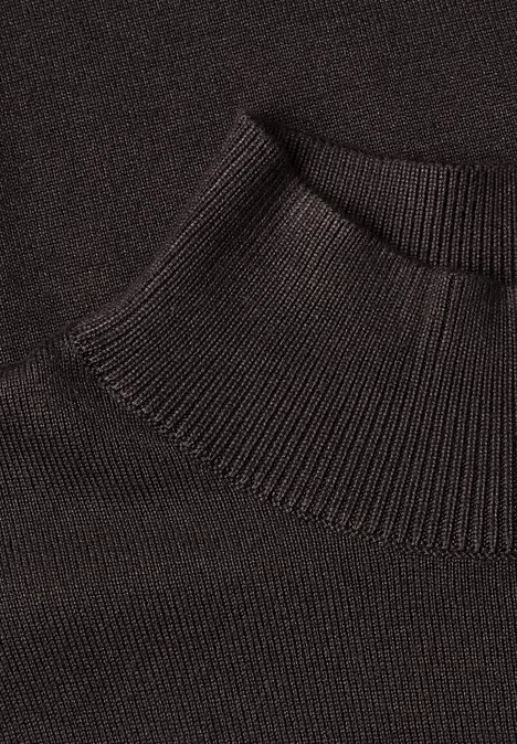 Nahaufnahme eines schwarzen Rollkragenpullover-Kragens aus feiner Strickware.