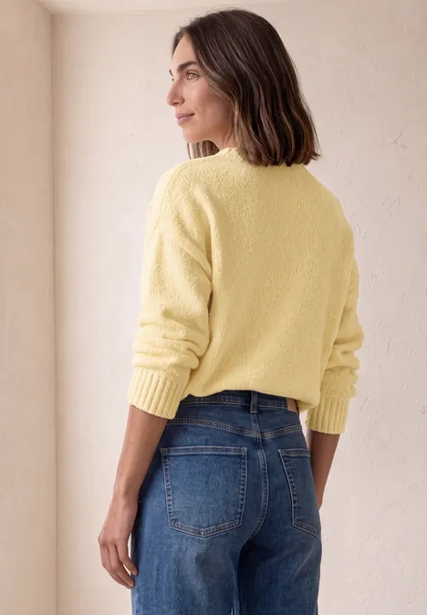 Chenille-Pullover mit U-Boot-Ausschnitt sunbeam yellow Frau in gelbem Pullover und Jeans, von hinten seitlich stehend vor neutralem Hintergrund.