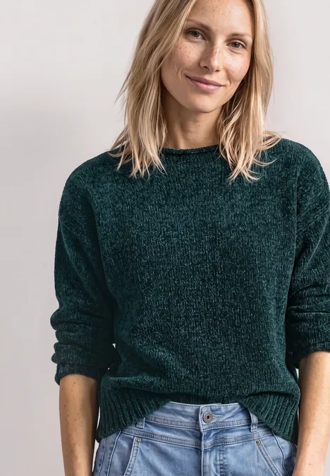 Chenille-Pullover mit U-Boot-Ausschnitt shadow teal Frau mit blondem Haar in grünem Pullover und Jeans vor hellem Hintergrund, lächelnd.