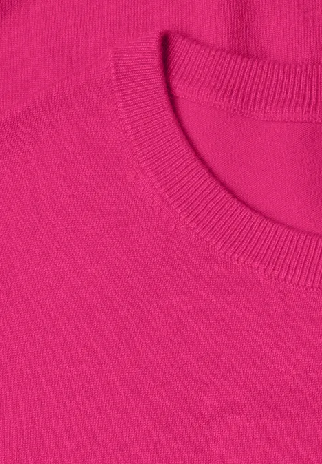 Close-up van een felroze T-shirtkraag met geribbelde structuur en nette afwerking.