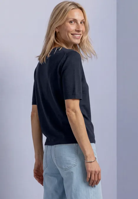 T-shirt met korte mouwen en ronde hals in effen kleur darkest blue Blonde vrouw in zwart shirt en spijkerbroek kijkt glimlachend over haar schouder.