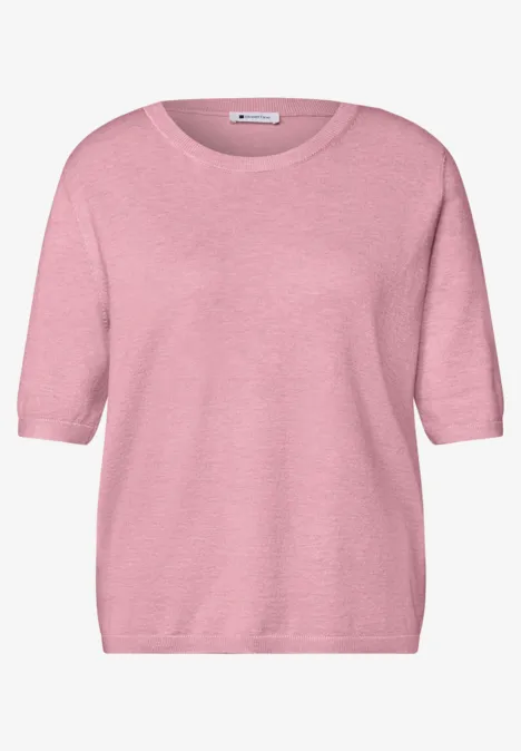 Een lichtroze shirt met driekwart mouwen en een ronde hals.