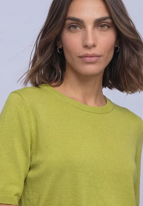 T-shirt met korte mouwen en ronde hals in effen kleur apple lime Vrouw met halflang bruin haar draagt een lichtgroen fijngebreid shirt en zilveren oorringen.