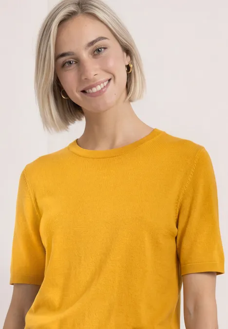 T-shirt met korte mouwen en ronde hals in effen kleur saffron yellow Lachende vrouw in mosterdgeel kort mouwtruitje tegen lichte achtergrond