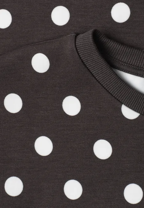 Schwarzes Shirt mit weißen Punkten und Rundhalsausschnitt.