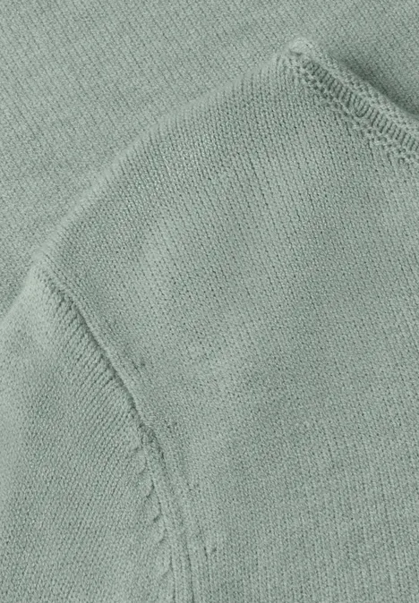Gros plan d’un tissu tricoté vert clair avec couture