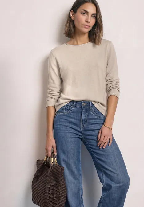 Pullover mit Boat Neck und Rollkanten clay sand mel. Frau in beigem Pullover und blauer Jeans mit brauner Geflecht-Tasche.