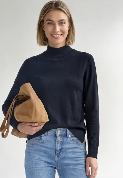 Basic Pullover mit Turtle Neck darkest blue Frau mit kurzem hellbraunem Haar trägt schwarzen Rollkragenpullover und blaue Jeans, hält eine braune Tasche.
