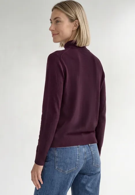 Basic Pullover mit Turtle Neck berry maroon Frau in Jeans und bordeauxfarbenem Rollkragenpullover, seitlich stehend