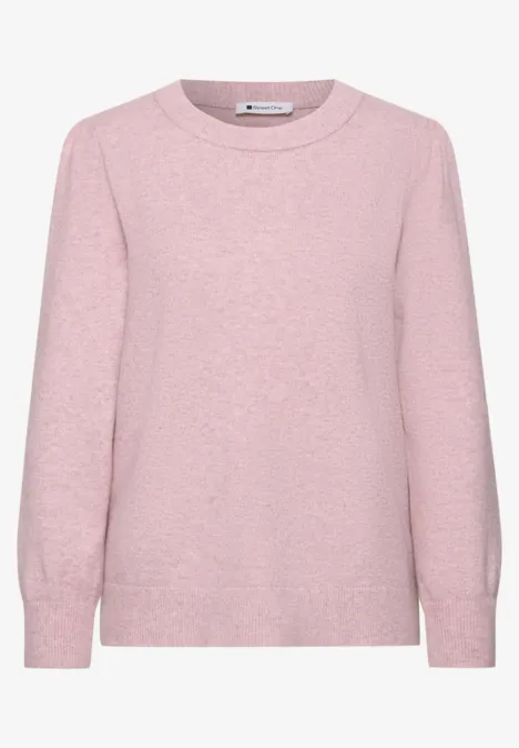 Ein zartrosa Pullover mit Rundhalsausschnitt und langen Ärmeln.
