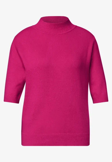 Ein fuchsiafarbener Pullover mit hohem Kragen und halblangen Ärmeln.