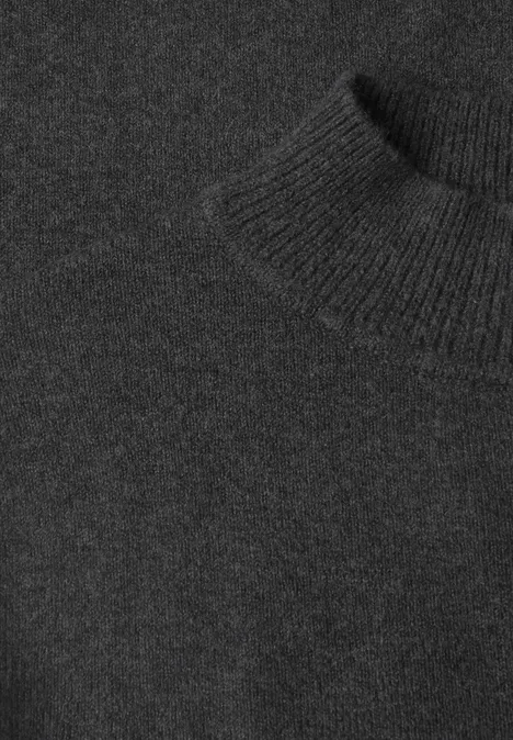 Nahaufnahme eines schwarzen Rollkragenpullovers aus Strickmaterial.