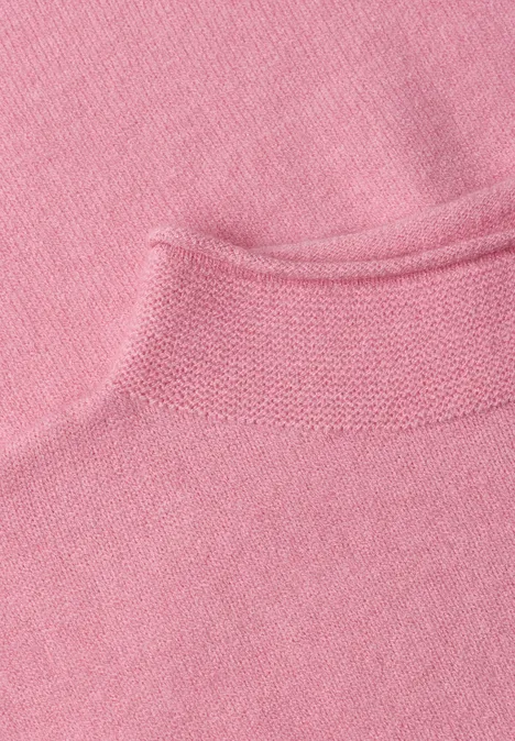 Gros plan sur un tissu tricoté rose avec surface douce et bord retroussé.