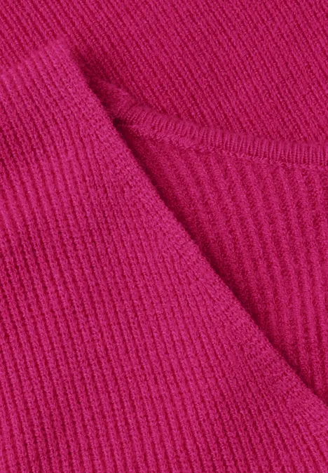 Gros plan sur un tissu côtelé rose vif avec col en V.