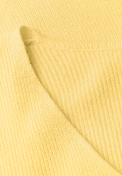 Gros plan d'un tissu tricoté côtelé jaune avec encolure ronde