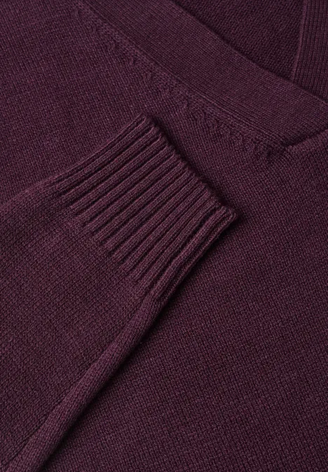 Gros plan d'un pull en maille bordeaux à col V.