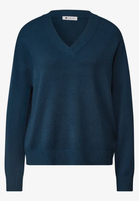 Pull bleu foncé à col en V avec finitions en côte et manches longues.