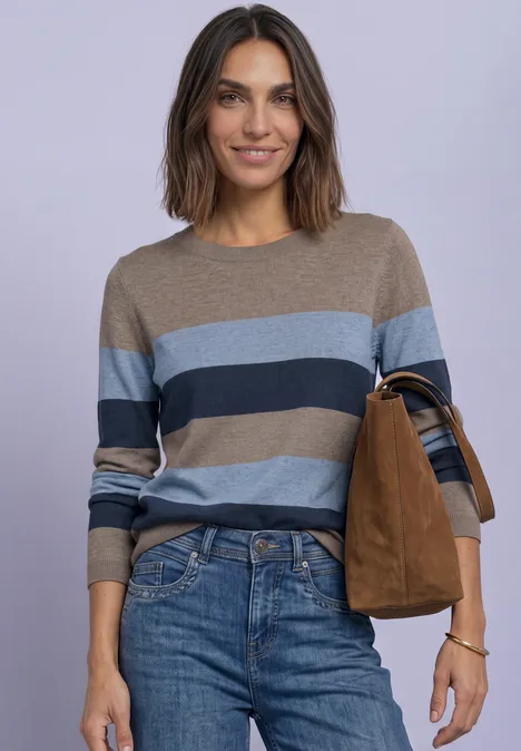 Pullover mit Rundhals und Streifen deep blue Lächelnde Frau in blau-braunem Streifenpullover, Jeans und brauner Tasche vor lila Hintergrund.