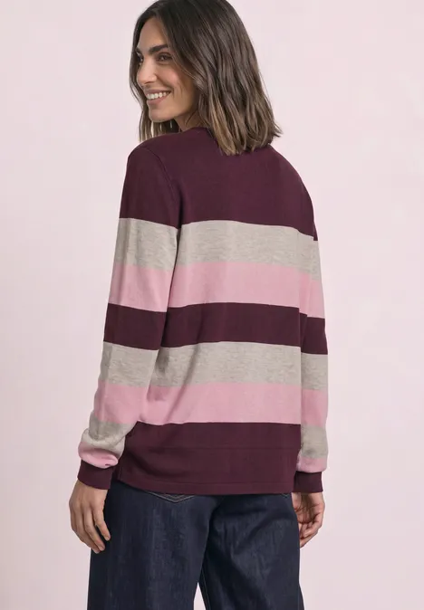 Pullover mit Rundhals und Streifen rustic rouge Eine Frau trägt einen breit gestreiften Pullover in Bordeaux, Rosa und Beige, schaut lächelnd über die Schulter.