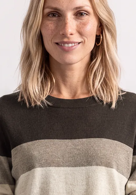 Pullover mit Rundhals und Streifen black coffee Eine lächelnde blonde Frau mit Sommersprossen, gestreiftem Pullover und goldenen Creolen.
