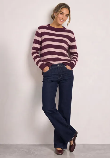 Pullover mit Boat Neck und Streifen berry maroon Junge Frau trägt gestreiften Pullover, weite Jeans und Loafers, steht lächelnd vor weißem Hintergrund.