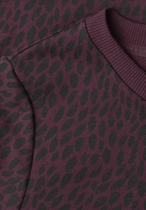 Bordeauxroter Pullover mit schwarzem Blattmuster und geripptem Rundhals.