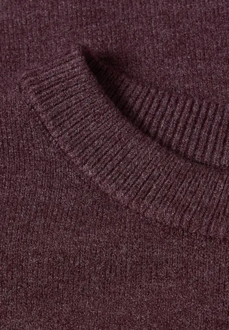 Nahaufnahme eines burgunderroten Strickpullovers mit geripptem Kragen.