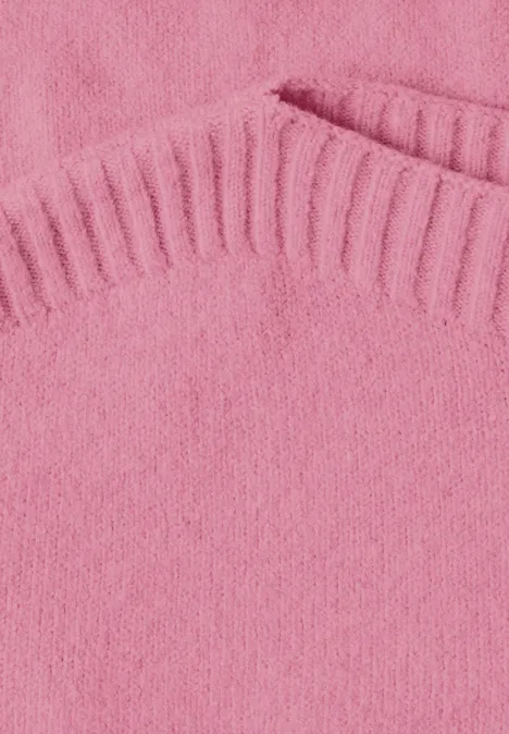 Nahaufnahme eines rosa Strickpullovers mit Rippenstrick am Kragen und einer Tasche.