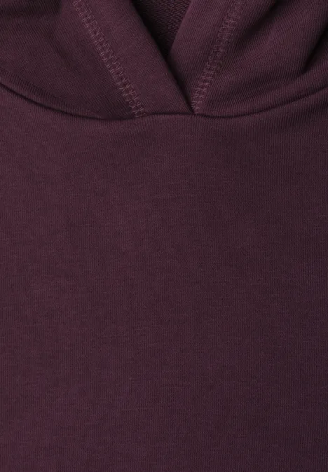 Nahaufnahme eines dunkelvioletten Kapuzenhoodies mit sichtbaren Nähten und Stoffstruktur.