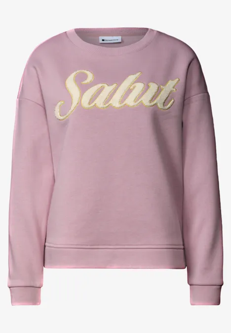 Rosa Sweatshirt mit gelbem Schriftzug „Salut“ in verspielter Schrift.