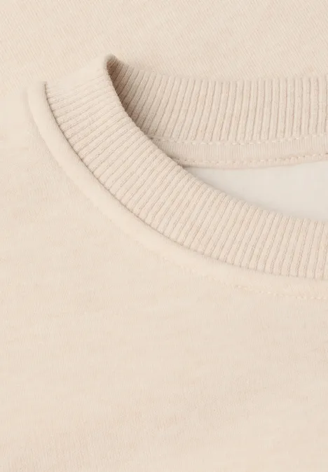 Nahaufnahme eines beigen T-Shirt-Kragens mit feiner Rippstruktur