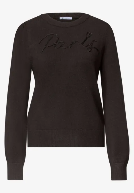 Schwarzer Pullover mit langen Ärmeln und dezentem Logo-Stick auf der Brust.