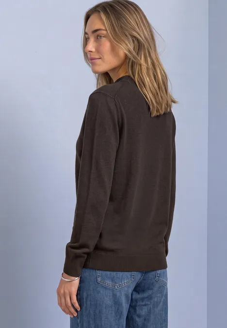 Pullover in Unifarbe mit Rundhals black coffee Frau in dunklem Pullover und blauen Jeans steht seitlich vor hellem Hintergrund.
