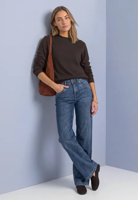 Pullover in Unifarbe mit Rundhals black coffee Eine Frau lehnt entspannt an lilafarbener Wand, trägt schwarzen Pullover, blaue Jeans und braune Schultertasche.