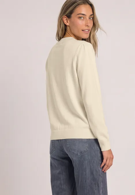 Pullover in Unifarbe mit Rundhals pure beige Frau in hellem Pullover und Jeans blickt lächelnd über die Schulter.