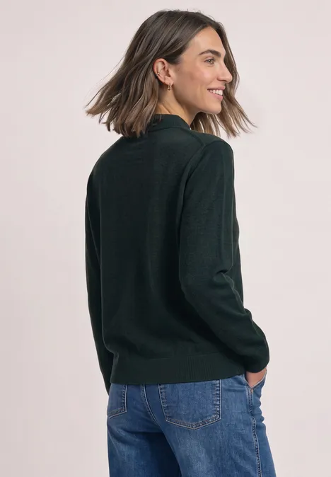 Pullover in Unifarbe mit Rundhals stormy green Eine junge Frau im dunkelgrünen Pullover und Jeans lächelt, während sie über die Schulter schaut.