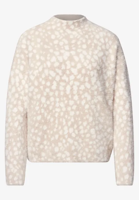 Beiger Pullover mit rundem Ausschnitt und zartem weißem Fleckenmuster.