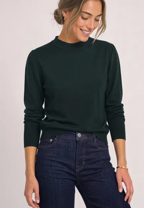 Langarm Pullover mit Turtle Neck und Raffung stormy green Frau im dunkelgrünen Pullover und Jeans lächelt und schaut nach unten.