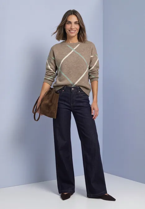 Pullover mit Boat Neck und Intarsien-Muster sanded amber mel. Frau in beige-kariertem Pullover, weiten dunkelblauen Hosen und brauner Tasche vor hellem Hintergrund.