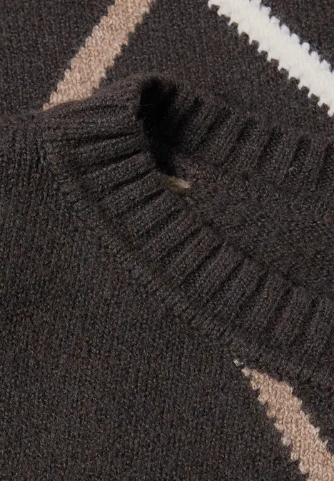 Nahaufnahme eines dunkelbraunen Strickpullovers mit V-Ausschnitt und diagonalen beigen & weißen Streifen.
