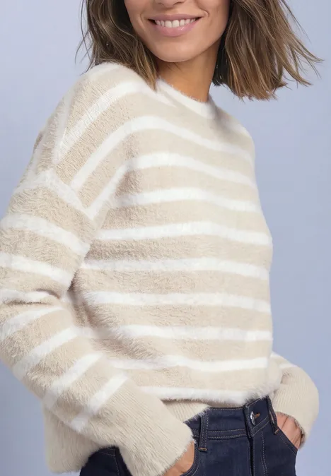 Langarm Pullover mit Rundhals und Streifen clay sand Eine Frau trägt einen creme-weiß gestreiften, flauschigen Pullover, lässig in dunkle Jeans gesteckt.