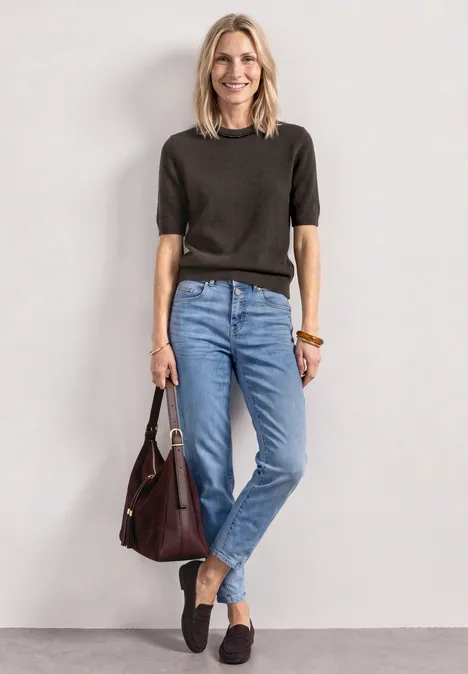 Kurzarm Pullover mit Schmuckdetail black coffee mel. Frau in lässigem Outfit: schwarzes Kurzarmshirt, blaue Jeans, schwarze Loafers und eine bordeauxrote Handtasche.