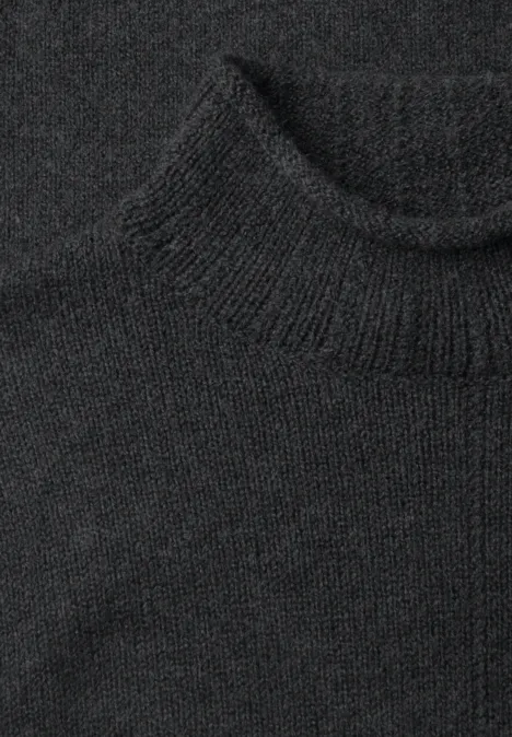Schwarzer Rollkragenpullover aus grobem Strick.