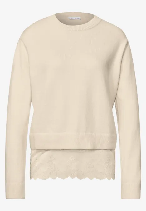 Beiger Strickpullover mit runder Kragen und spitzenbesetztem Saum.