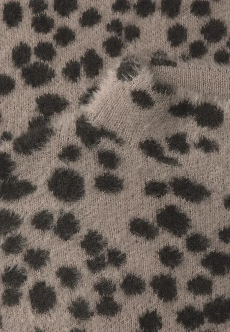 Flauschiger Stoff mit schwarzen Flecken auf gräulich-braunem Grund