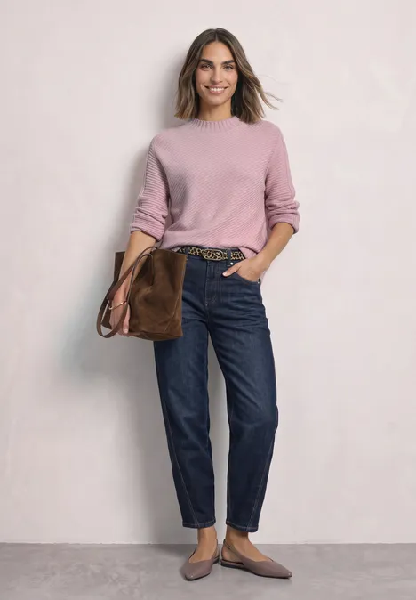 Langarm Pullover mit Turtle Neck und Struktur quiet rose mel. Frau in rosafarbenem Pullover, dunklen Jeans, brauner Tasche und flachen Schuhen vor hellem Hintergrund.