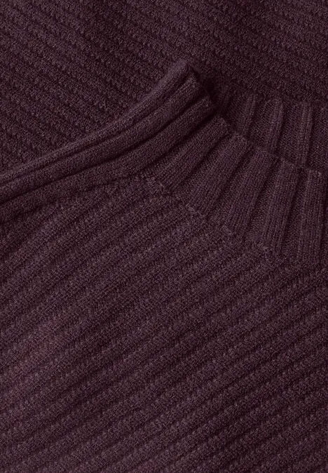 Nahaufnahme eines burgunderfarbenen, gerippten Strickstoffs mit hohem Kragen
